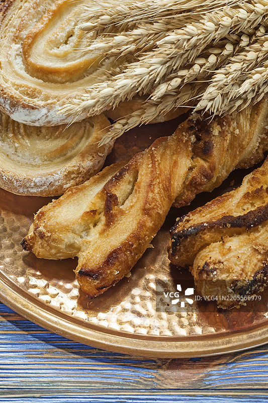 古董木板上的小麦穗烤面包和黄铜托盘图片素材
