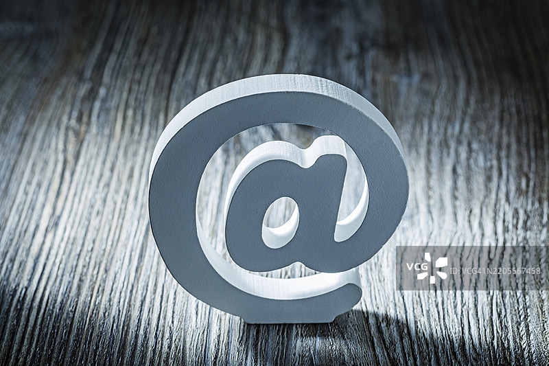 复古灰木上的白色邮件符号图片素材