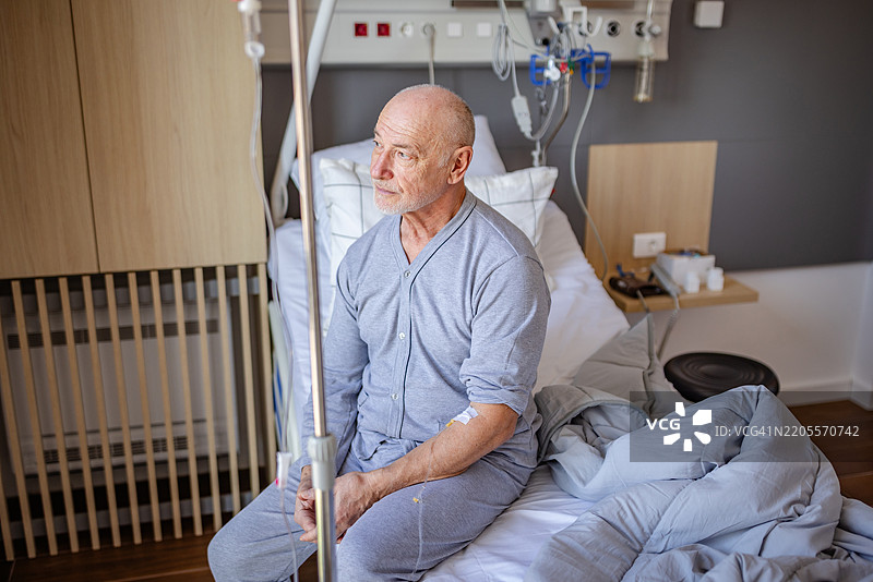老年人在医院病床上接受护理，回顾他的康复之旅以及医疗专业人员的支持图片素材
