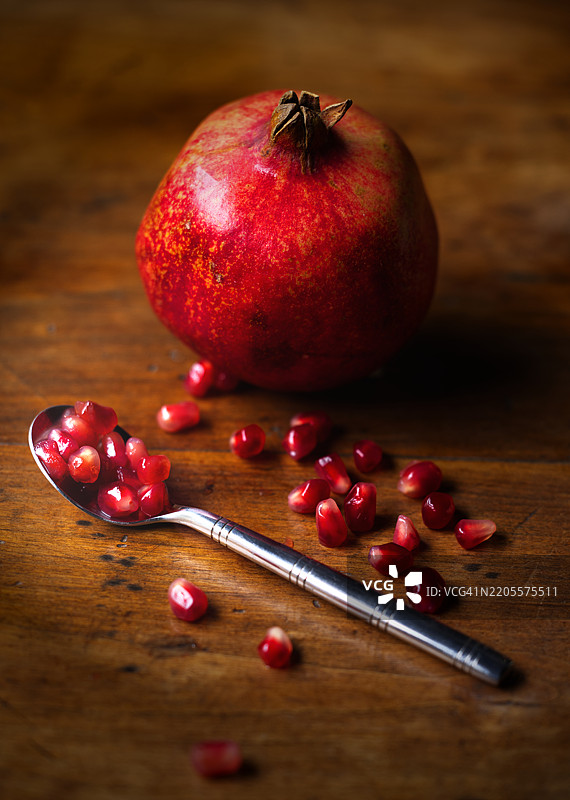 高角度视图的石榴和桌子上的勺子图片素材