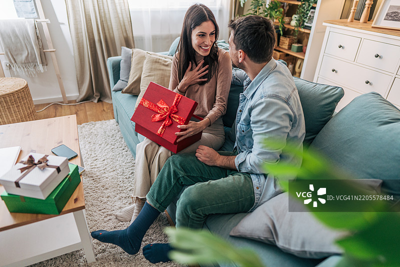 年轻女性与男友一起拆圣诞礼物图片素材