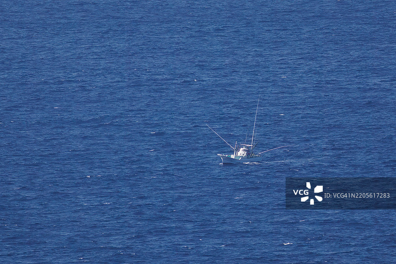 一艘渔船驶向海岸外。八丈岛，伊豆群岛，东京 - 2025年3月1日。图片素材