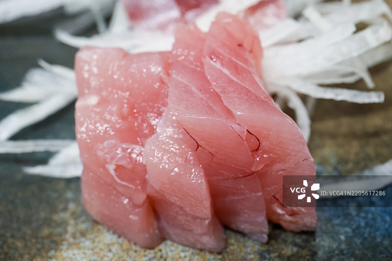 八丈岛的梅岛黑鲔鱼(幼年黄鳍金枪鱼,Thunnus albacares)和大眼金枪鱼(Seriola dumerili)刺身。客栈里丰盛的海鲜晚餐。八丈岛,伊豆群岛,东京 - 2025年3月1日。图片素材