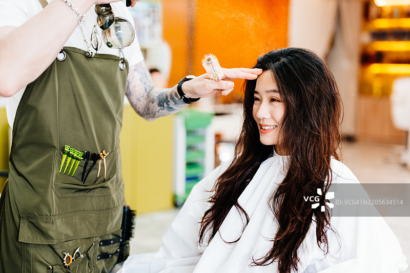 年轻的亚洲女性在发廊里做美丽的发型。图片素材