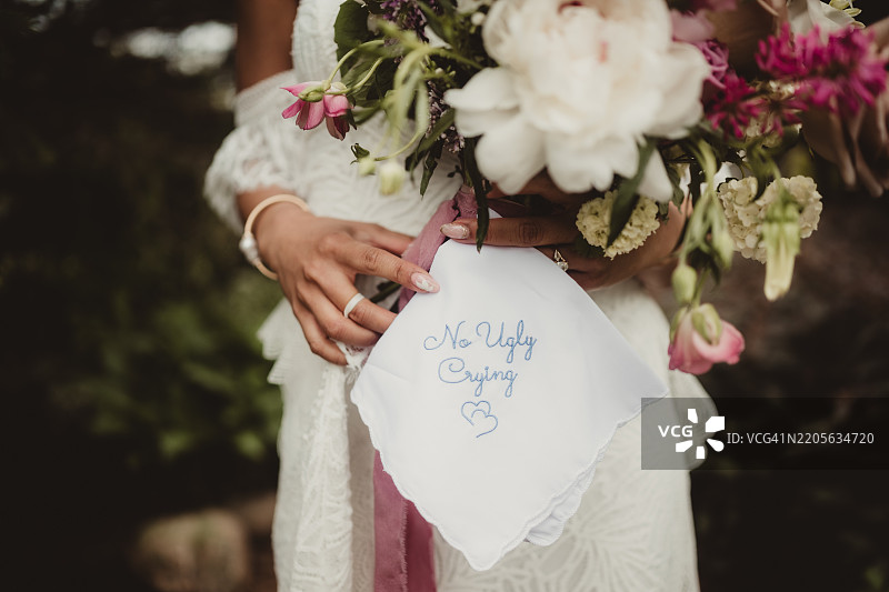 新娘穿着婚纱，手持手帕和花束图片素材