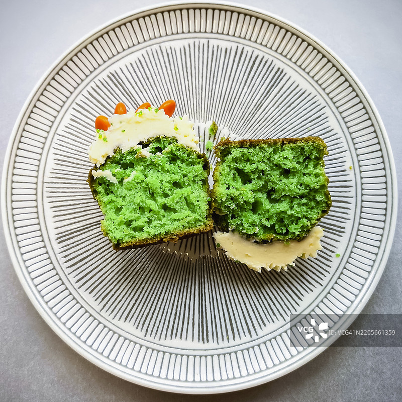 绿色圣帕特里克节杯子蛋糕，切成两半，放在装饰盘上，俯视图，方形图片图片素材