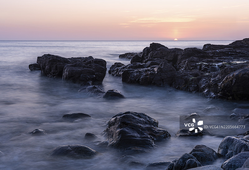 肯尼杰克谷海滩的日落。岩石与海洋。海景。长时间曝光。圣贾斯特,彭赞斯,康沃尔,英格兰,英国图片素材