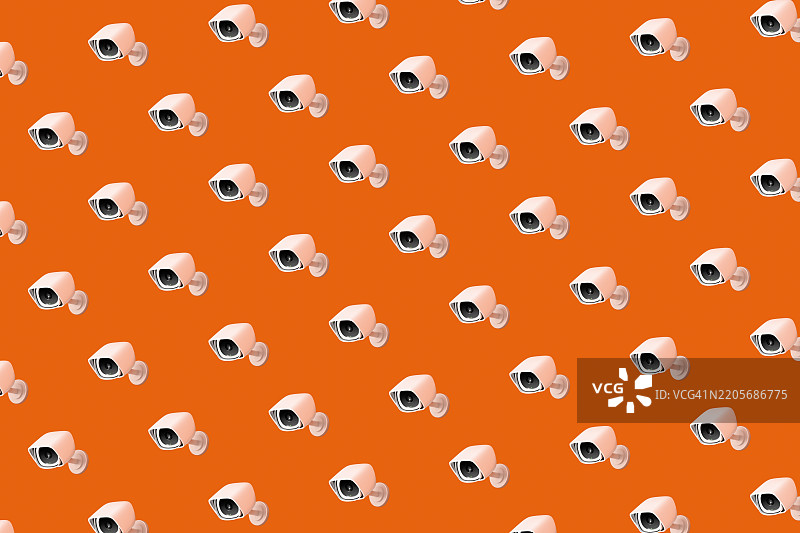 明亮橙色背景上的监控摄像头图案图片素材