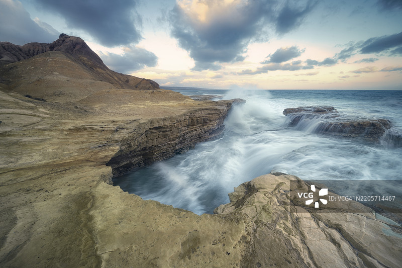 澳大利亚日落时分的戏剧性海岸海景，波涛汹涌与崎岖的岩石形成对比图片素材