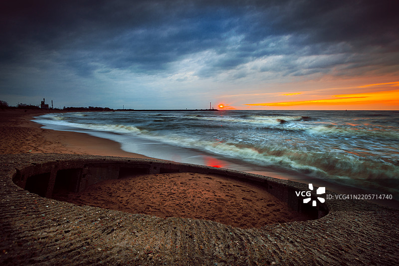 立陶宛克莱佩达海滩上废弃的圆形防御工事的日落图片素材