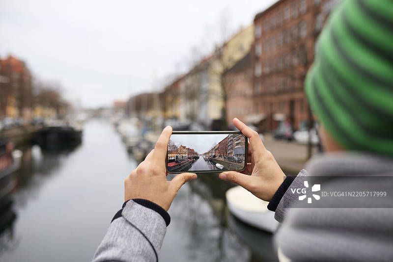 男子在丹麦哥本哈根的基督教港拍摄运河景观图片素材