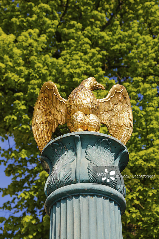 位于德国巴登-符腾堡州佐伦阿尔布区罗森费尔德的基督教镇教堂前的喷泉,绿色喷泉上有金色鸟雕塑,细节,鸟雕塑。图片素材
