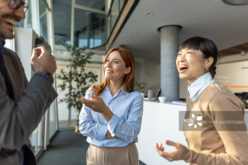 愉快的商务团队在办公室休息时间一起欢笑图片素材