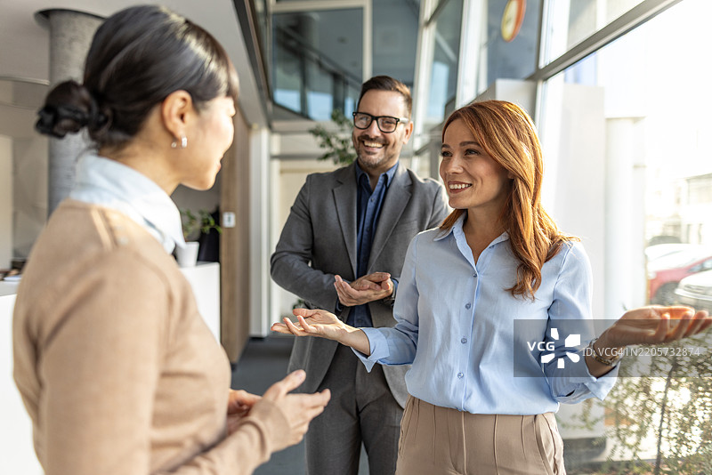 商务人士在现代办公室中交谈和手势交流图片素材