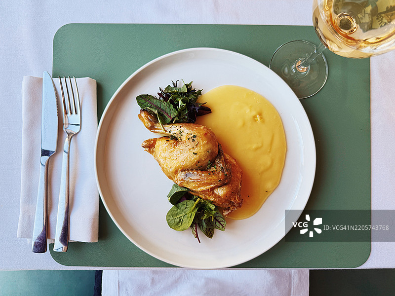 餐厅内高角度视图的鸡肉和土豆泥，搭配白葡萄酒图片素材