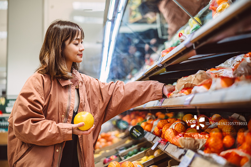 快乐的女性在超市购买新鲜农产品图片素材