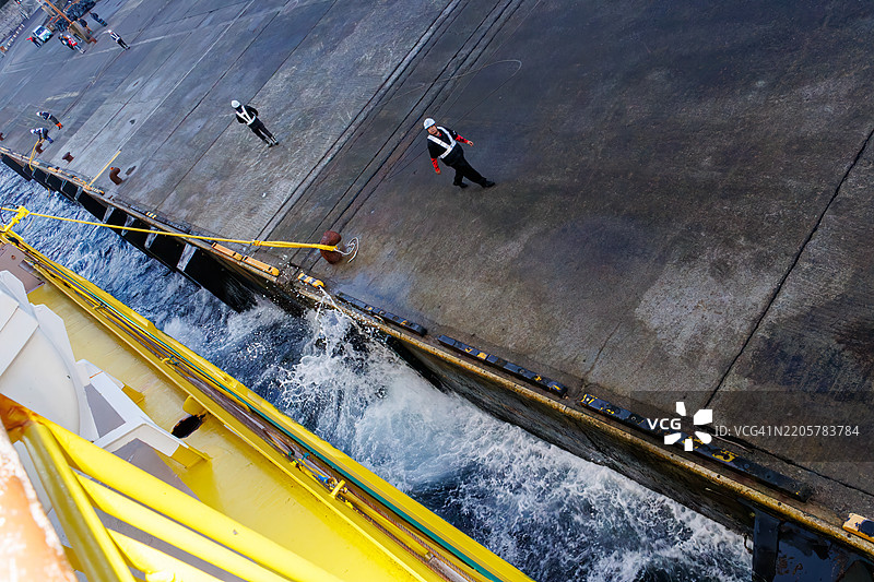 三宅岛港口相对平静。港口工人正在进行停靠作业。三宅岛，黎明时分的三宅岛港口。图片素材