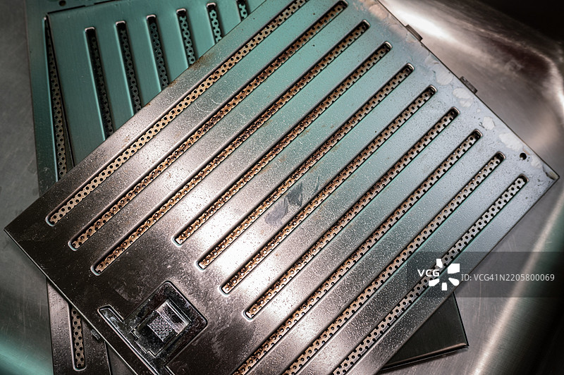 油污附着在抽油烟机过滤网。根据您的烹饪习惯，每两到三个月清洁一次过滤网。图片素材