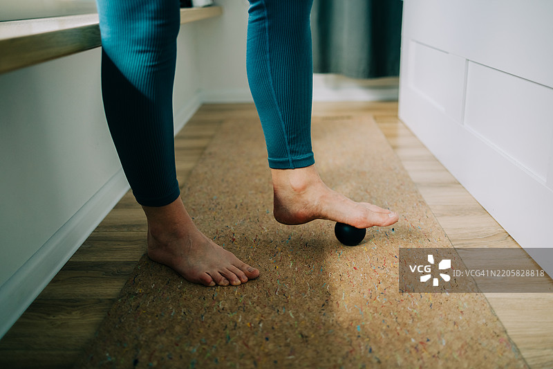 女人用球按摩自己的脚，进行自我按摩图片素材