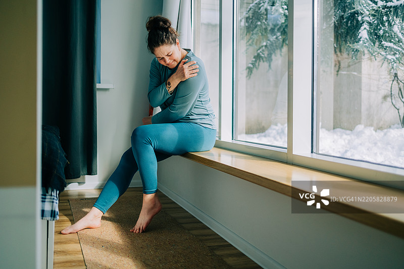 在家中肩部疼痛的女性图片素材