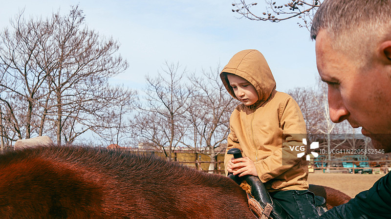男孩在牧场上骑马图片素材