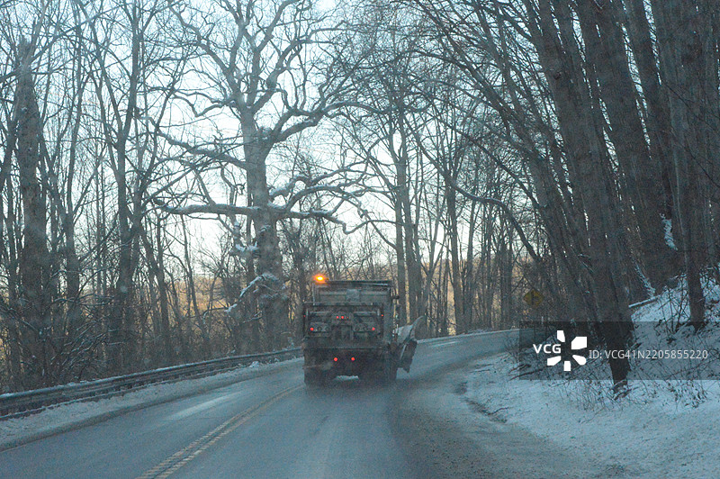 倾卸卡车在雪暴后撒盐和沙子图片素材
