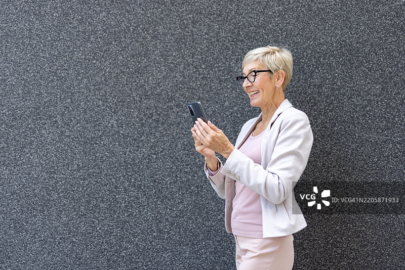 穿着西装的女性在查看智能手机图片素材