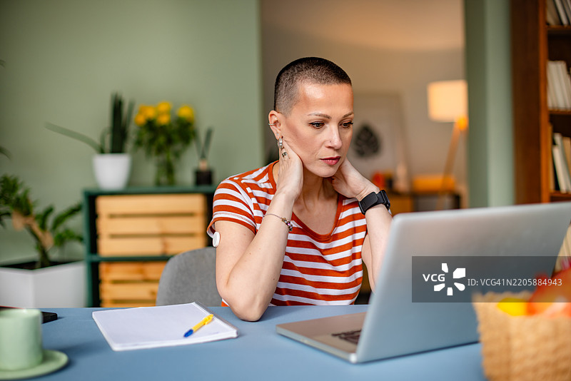 年轻女性在家中使用科技监测血糖，管理1型糖尿病图片素材