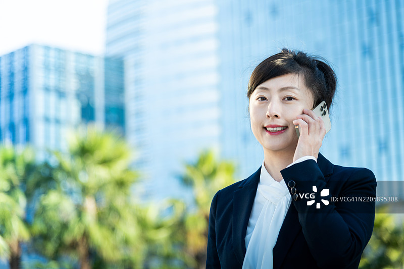 在办公楼外使用智能手机的女商人图片素材