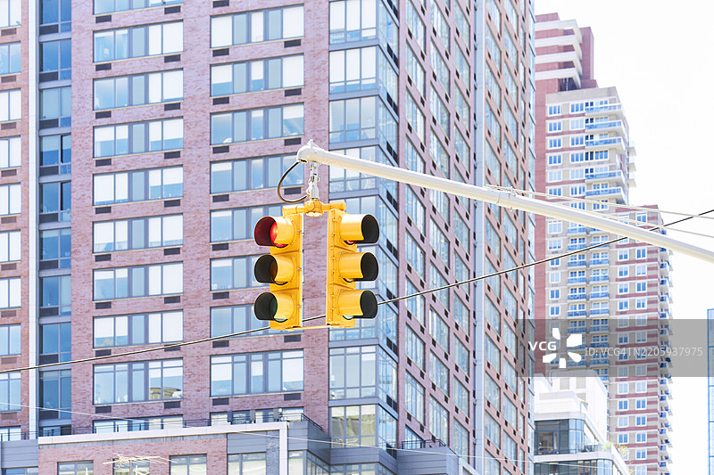 城市环境中现代建筑旁的红灯交通信号灯图片素材