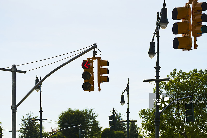 红色左转箭头交通信号灯悬挂在交叉口上图片素材