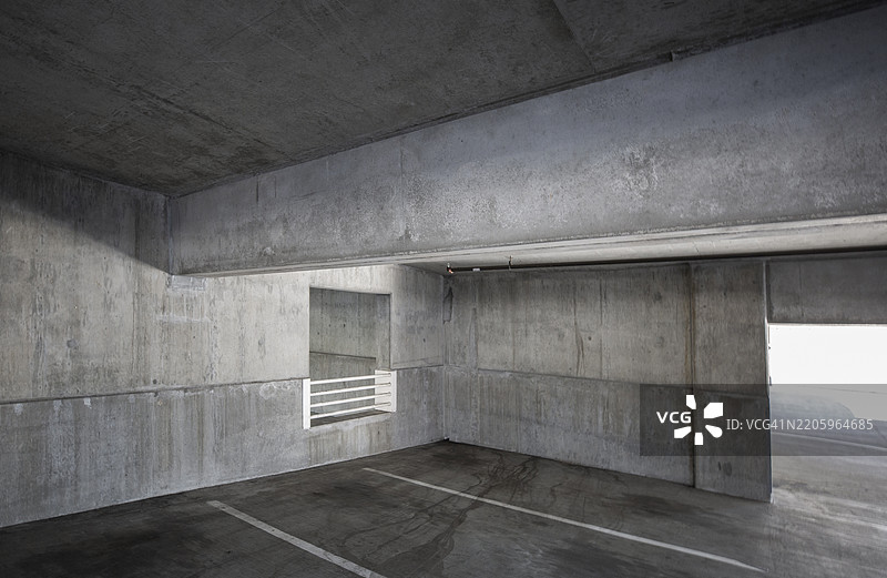 空荡荡的混凝土停车结构建筑，带有白色条纹线。图片素材