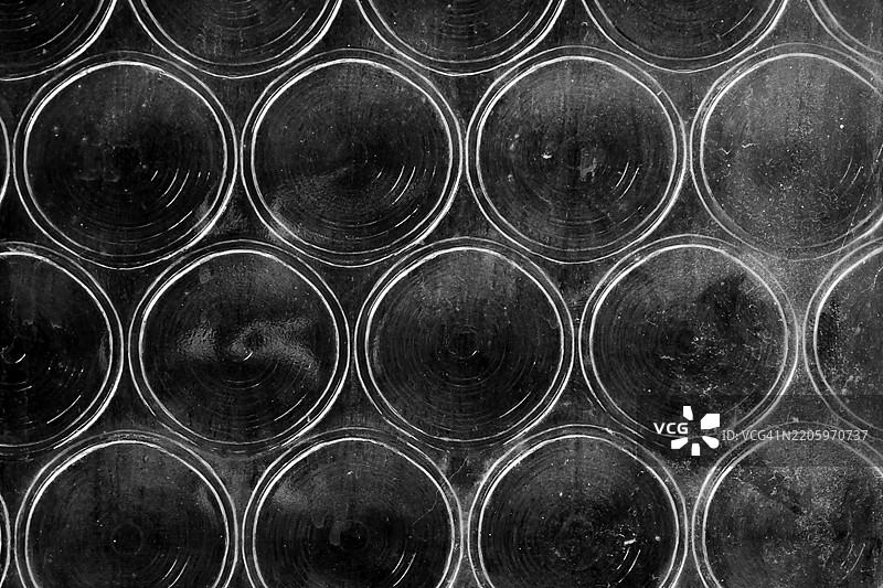 巴黎，法国，一扇老旧窗户的特写，窗户上有圆形图案。阳光。黑白色调。图片素材