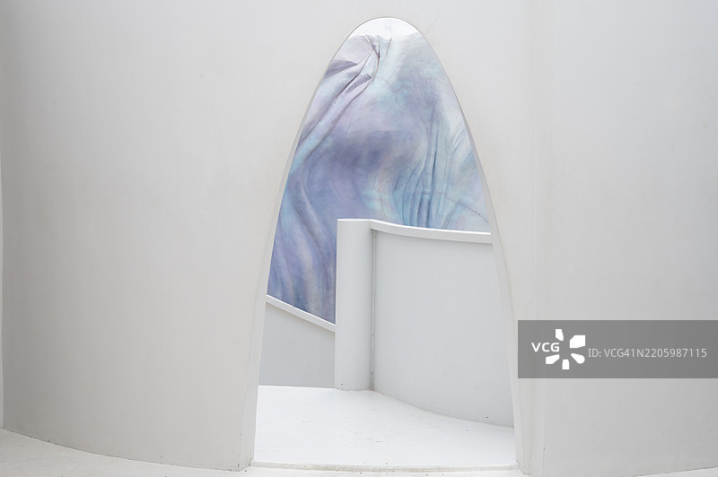 一座白色建筑，墙面为蓝色和紫色。图片素材