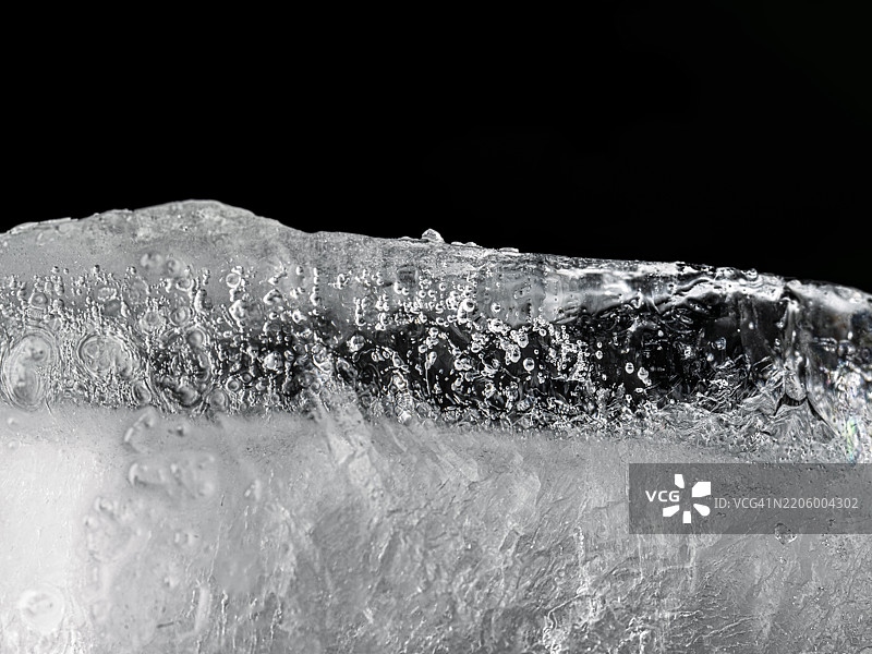 黑色背景上的纯水冰块的横截面。图片素材