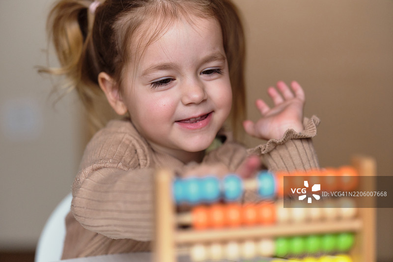 女孩在家里使用算盘玩具图片素材