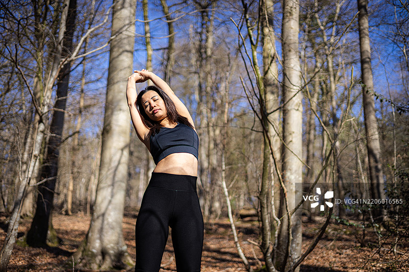 年轻的亚洲女士在英国西蒙兹雅特的森林中慢跑锻炼。图片素材