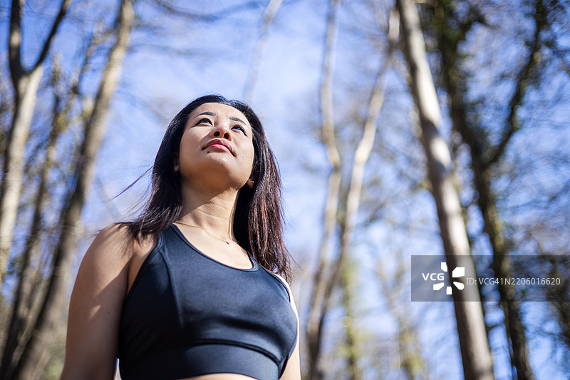 年轻的亚洲女士在英国西蒙兹雅特的森林中慢跑锻炼。图片素材