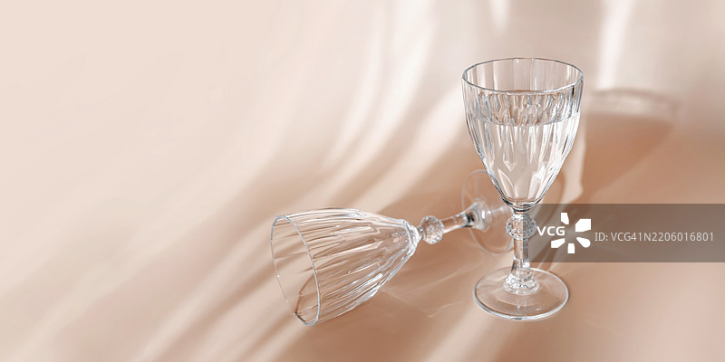 优雅的水晶酒杯，映射出水和阳光的反射图片素材
