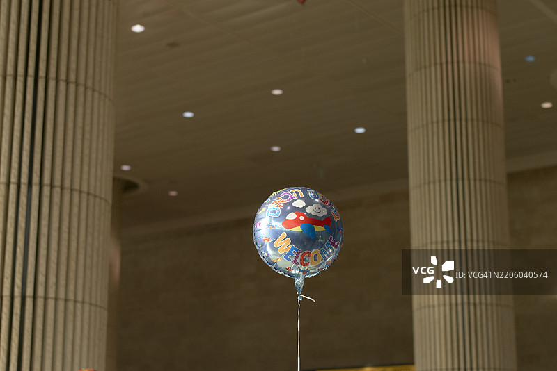 蓝色欢迎气球在机场到达区的高柱子间漂浮。以色列图片素材