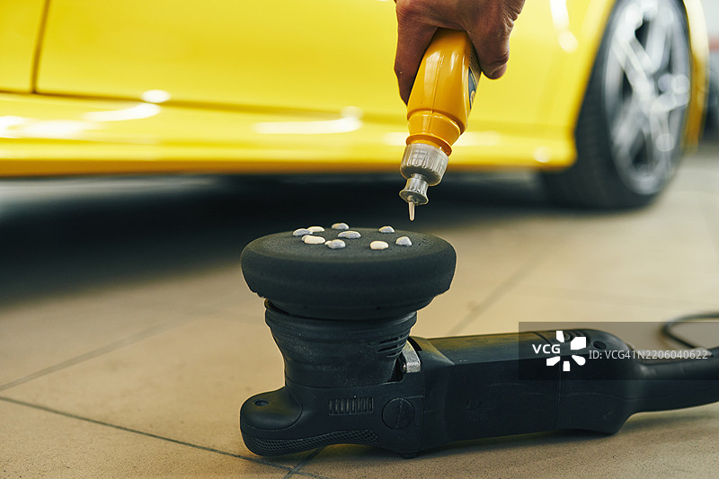 在车库中为黄色车辆的细节处理准备汽车抛光器应用器图片素材