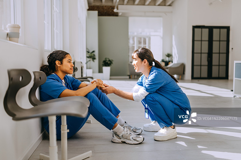 女同事在医院走廊安慰年轻护士图片素材