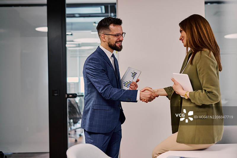 商人和女商人在办公室成功会议后握手图片素材