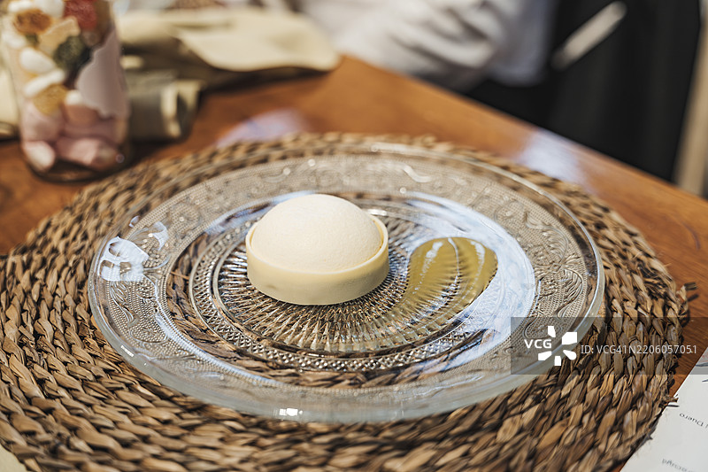 时尚呈现的白巧克力美食甜点，盛放在装饰性玻璃盘上。图片素材