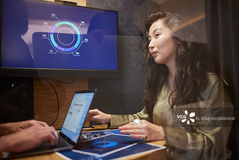 在隔音玻璃后，会议在一家企业办公室进行。图片素材