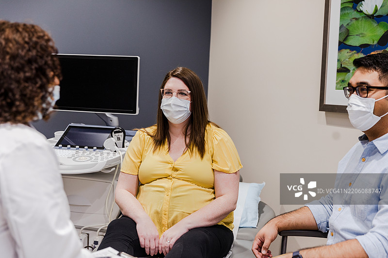 孕妇夫妇在医生办公室接受超声检查图片素材