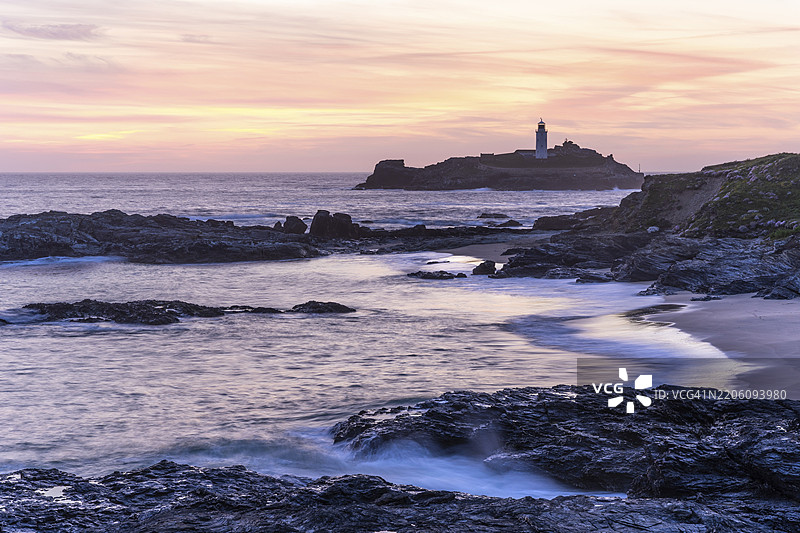 戈德雷维灯塔，位于戈德雷维岛上的灯塔。黄昏时分的日落。长时间曝光。英格兰，康沃尔，英国图片素材