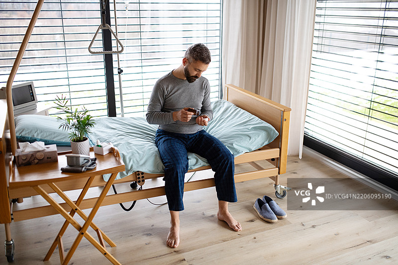 患者坐在医院病床上服用药片。图片素材