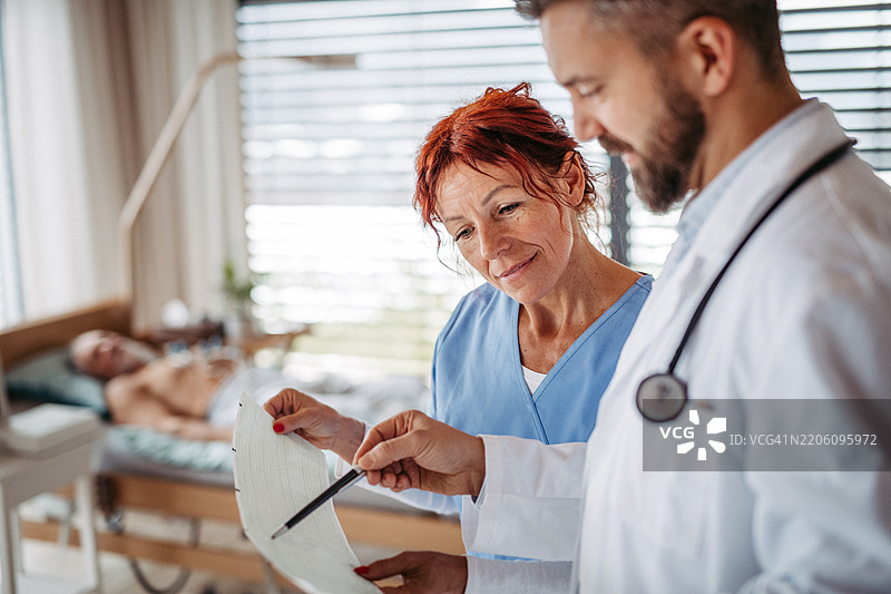 医疗工作者正在解读心电图，阅读心电图打印输出。图片素材