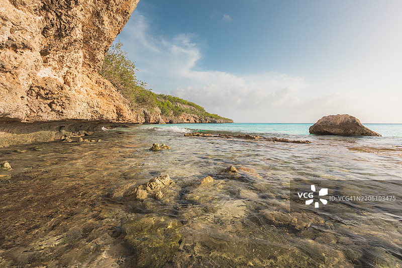 清澈海水和水下岩石的珊瑚礁悬崖海岸线，库拉索的卡斯阿巴海滩图片素材